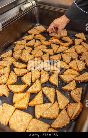 Multigrain seeded bread cut into pieces and toasted on metal tray in restaurant kitchen Stock Photo