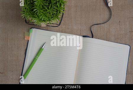 Open blank notepad with empty white pages laying on a table. cozy home setting. Stock Photo
