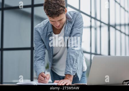 young office man at workplace making notes Stock Photo