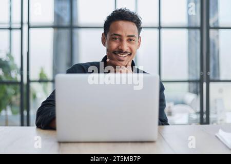 Creative Businessman Working at Desk with Laptop in Modern Office Stock Photo