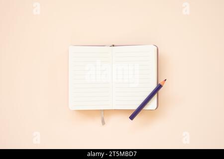 Blank lined note pad with colored pencil on pink desk background. top view Stock Photo