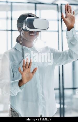 Businesswoman using vr glasses to view educational material and financial documents Stock Photo