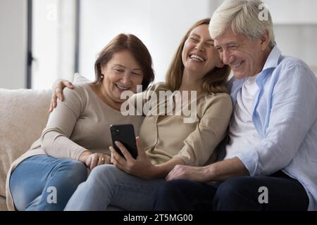 Cheerful older couple of parents and daughter meeting at home Stock Photo