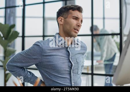 Male getting up and stretching to straighten his back Stock Photo