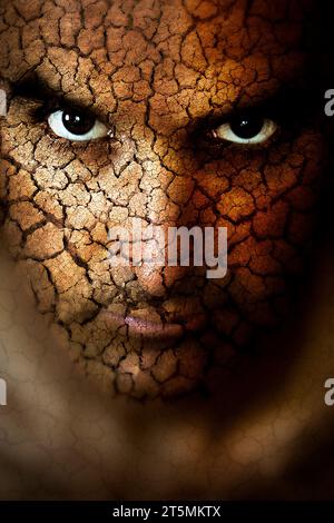 A portrait of a mans face with cracked desert mud-super imposed onto the skin. Stock Photo