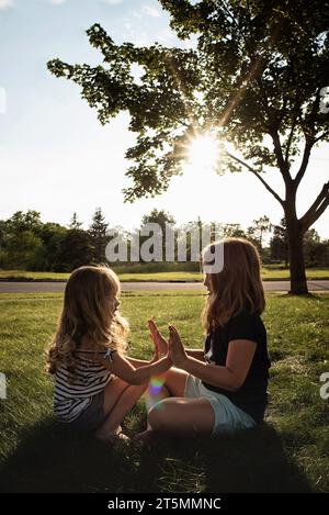 Young sisters playing together outdoors in summer Stock Photo