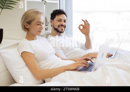 Mature people spending time at home using modern gadgets Stock Photo