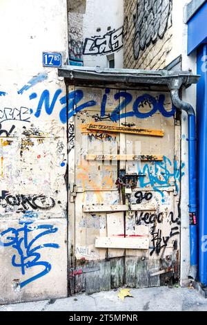Boarded-up and paint tagged doorway in Montmartre, Paris 18, France. Stock Photo