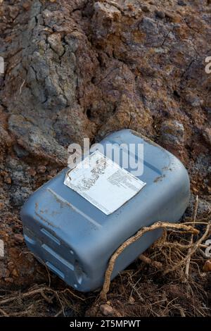 plastic chemical container washed up on a beach. hazardous waste container stranded on the shoreline. plastic contaminated waste on coastline Stock Photo