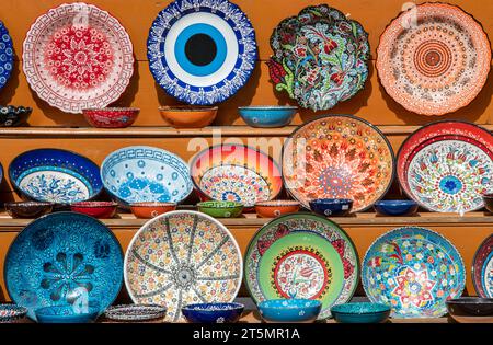 selection of brightly coloured ceramic plates and dishes on sale at a tourist shop on the greek island of crete Stock Photo