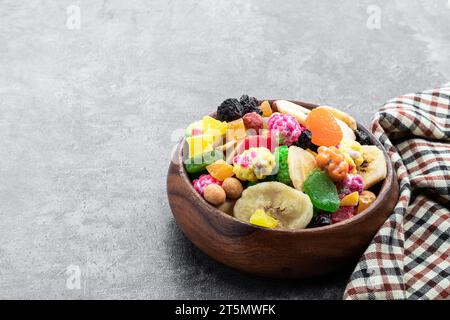Sugar  coated nuts and candied fruit in white plate on gray background Stock Photo