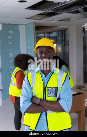 Portrait of happy african american male worker wearing hardhat in office, copy space Stock Photo