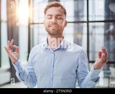 Young worker having break and resting after solving task Stock Photo