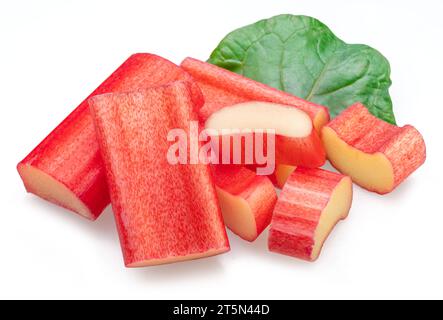 Red rhubarb stems' cuts over rhubarb leaves isolated on white background. Stock Photo