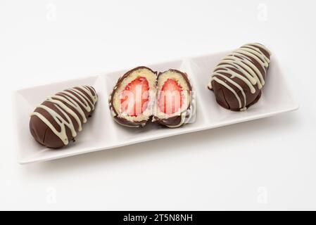 Delicious Homemade Brazilian Bonbons filled with "Beijinhos de Coco" and Strawberries. Isolated on white background. Stock Photo