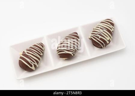 Delicious Homemade Brazilian Bonbons filled with "Beijinhos de Coco" and Strawberries. Isolated on white background. Stock Photo