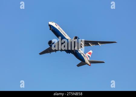 A British Airways 777-236ER climbing out of London Heathrow into the autumnal golden hour sunshine Stock Photo