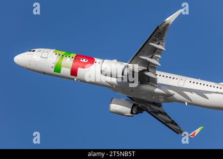 A TAP Portugal Airbus A321-251N Neo climbing and banking out of London Heathrow airport into the late afternoon autumnal sunshine Stock Photo