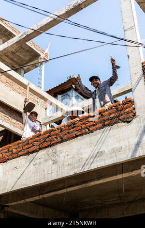 Three men on a building site in Bali, Indonesia Stock Photo