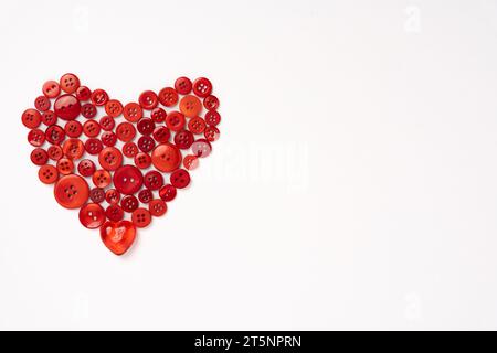 Red Plastic Buttons Arranged in a Heart Shape Isolated on a White Background Stock Photo