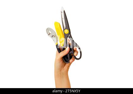 Scissors, pliers and a knife for cutting paper in hand on white background. Construction tools at arm's length, isolated on a white background Stock Photo