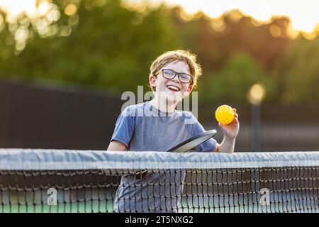 Young boy with pickleball gear on court. Stock Photo