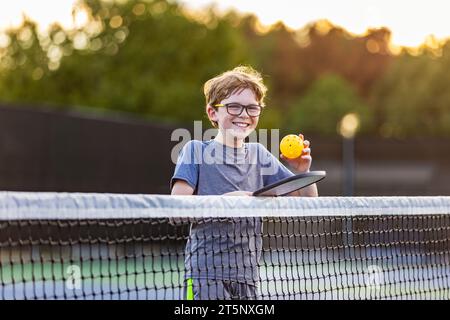 Young boy with pickleball gear on court. Stock Photo