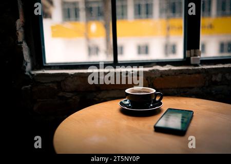 Coffee cup on wooden table in coffee shop, stock photo Stock Photo