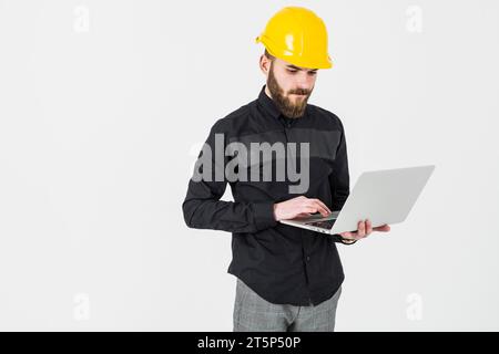 Male engineer wearing hardhat using laptop against white background Stock Photo