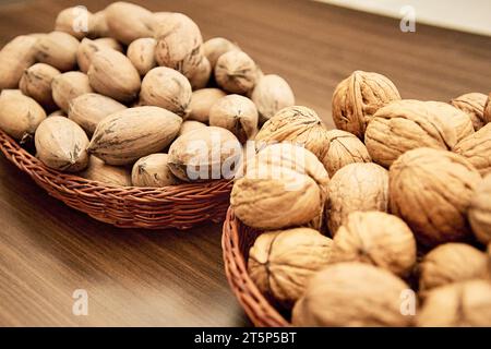 Pecans and walnuts on the table in a wicker basket. Stock Photo