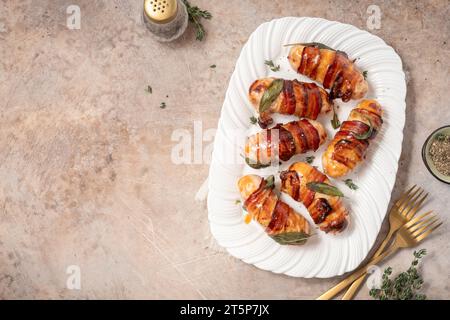 Christmas Pigs in blankets, sausages wrapped in bacon with sage leaves Stock Photo