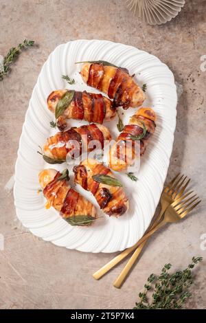 Christmas Pigs in blankets, sausages wrapped in bacon with sage leaves Stock Photo