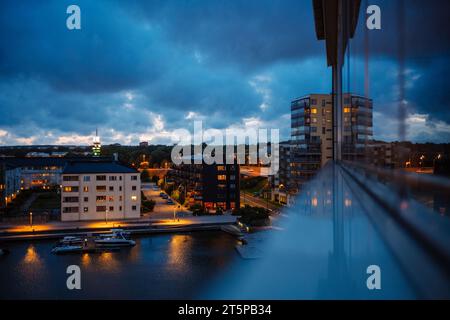 Harbor and city neighborhood view in Gothenburg, Sweden from airport window with reflection at dusk blue hour. Stock Photo