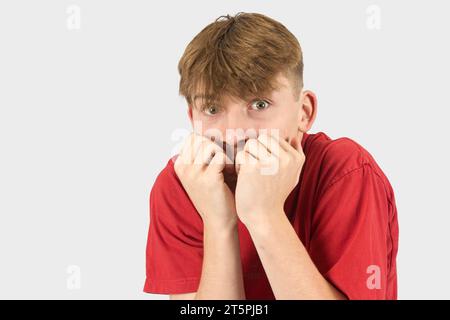 A studio portrait of a nervous fifteen year old teenage boy Stock Photo