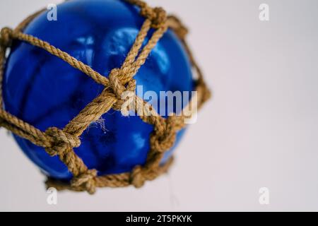 Glass fishing net round buoy. One glass sphere with ropes isolated on white  background. Scandinavian traditional decor Stock Photo - Alamy