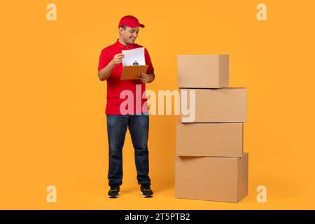 Courier with stack of parcels and clipboard near huge smartphone on ...