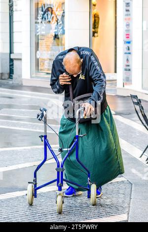 Disabled man using walking aid and speaking on telephone - Tours, Indre-et-Loire (37), France. Stock Photo
