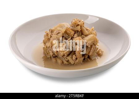 Stewed thistles with anchovy and garlic sauce in white plate isolated on white with clipping path Stock Photo