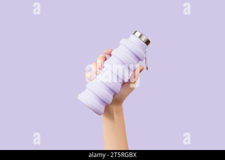 Womans hand holding collapsible reusable lilac water bottle on purple background. Zero waste Stock Photo