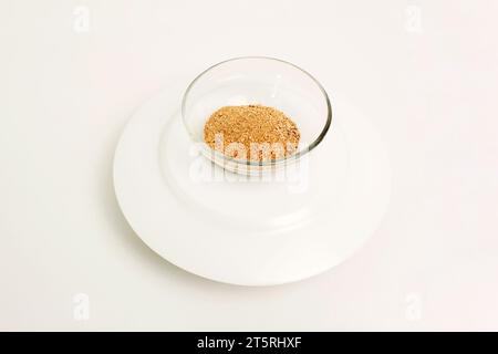 Dry ground ginger in a glass plate on a white background. Close-up. Top view. Stock Photo