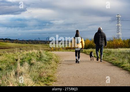 Walkers at Cutacre Country Park near Bolton, Greater Manchester, with views across to Manchester City centre Stock Photo