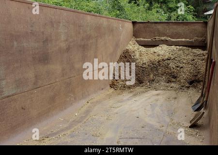 Rusty metal or iron bin containing and storing agricultural inputs: animal manure mixed with sawdust for the production and use of organic fertilizers Stock Photo