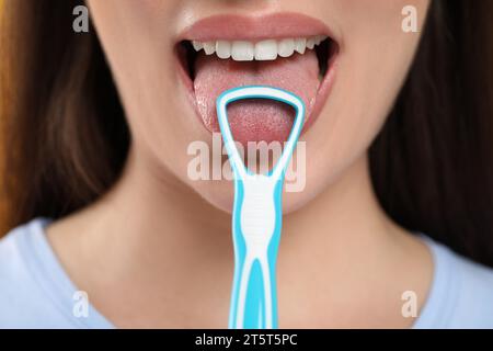 Woman brushing her tongue with cleaner, closeup Stock Photo