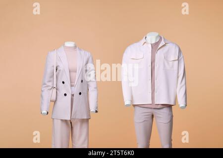 Male and female mannequins dressed in stylish outfits on beige background Stock Photo