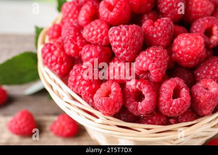 Tasty ripe raspberries in wicker basket, closeup Stock Photo
