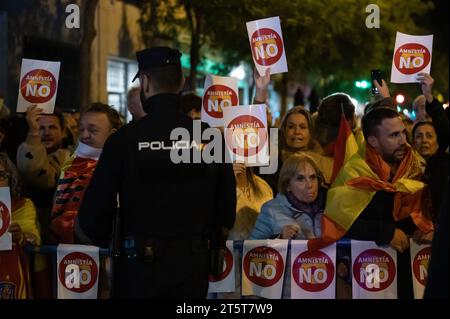 Madrid, Spain. 06th Nov, 2023. People wearing Spanish flags hold placards during a protest in front socialist party PSOE headquarters against the government of Pedro Sanchez and the possible approval of an amnesty for Catalan separatist leaders that the government is negotiating to guarantee the investiture of the socialist candidate. Far right wing groups such as VOX party has supported the protests that have been carried out also in several Spanish cities. Credit: Marcos del Mazo/Alamy Live News Stock Photo