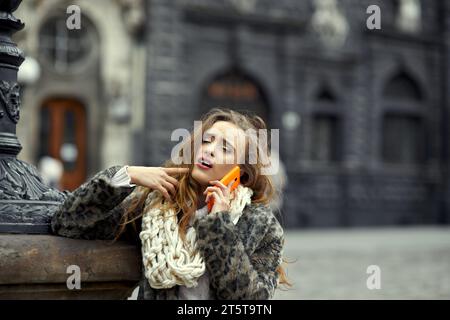 Beautiful woman calls the dentist for a consultation to schedule a meeting because of a toothache. Concept of online consultation by phone with doctor Stock Photo