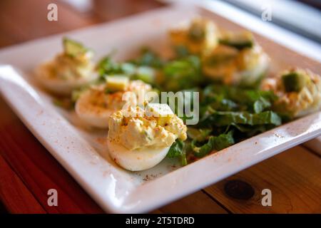 Organic Deviled Eggs topped with avocado Stock Photo