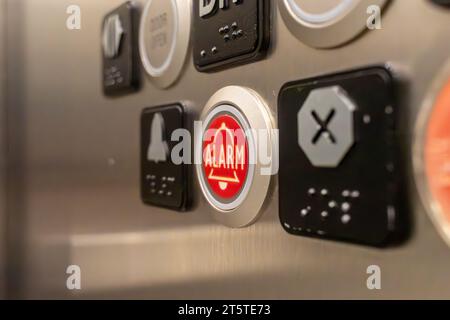 Elevator alarm button - close-up of red alarm button on elevator control panel Stock Photo