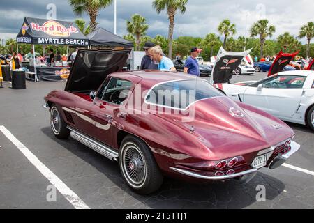 Men inspect an antique maroon 1967 Chevrolet Corvette coupe sports car at a car show in Myrtle Beach, South Carolina, USA. Stock Photo